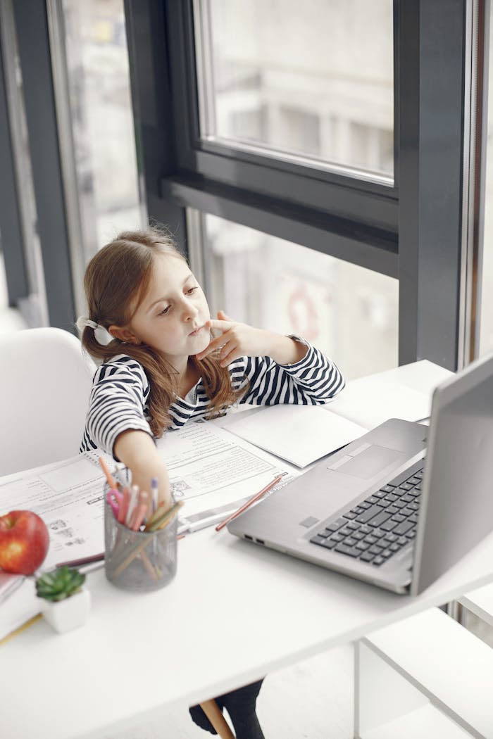 why-choose-us A young girl engaging in online learning at home using a laptop, emphasizing modern education.